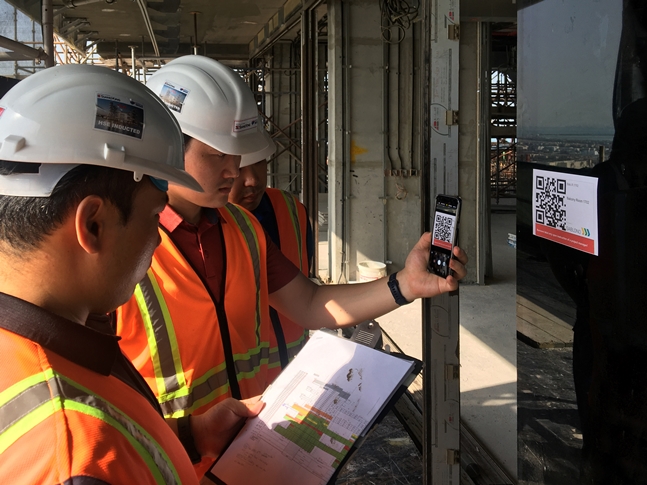 두바이 로얄 아틀란티스 리조트 & 레지던스 현장 직원들이 건물 벽면에 부착된 QR코드를 통해 실시간 공사 현황을 확인하고 있다.ⓒ쌍용건설