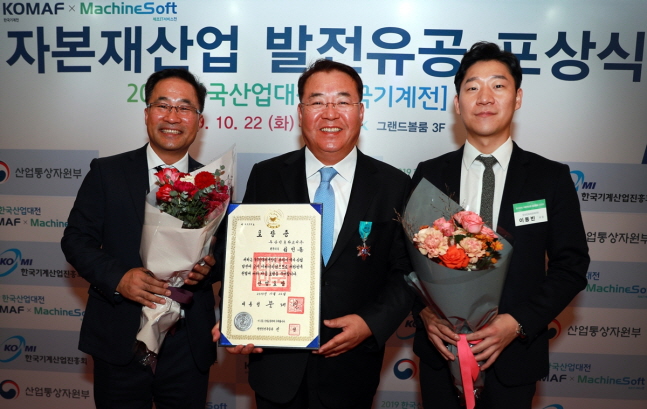 두산인프라코어는 김인동 전무(사진 가운데)가 22일 일산 킨텍스에서 열린 ‘2019 한국산업대전’ 개막식에서 한국 자본재산업 발전에 기여한 공로로 정부로부터 산업포장을 수상했다고 밝혔다.ⓒ두산인프라코어