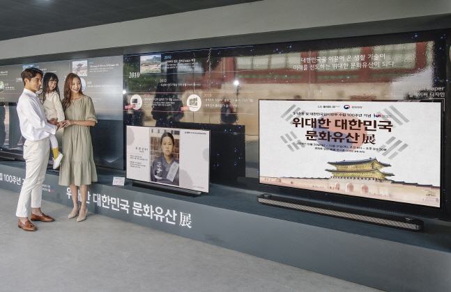 LG전자 모델들이 서울 경복궁에서 진행되는 '위대한 대한민국 문화유산 展'에서 올레드(OLED) TV로 선보이는 독립운동 영웅들 모습을 관람하고 있다.ⓒLG전자