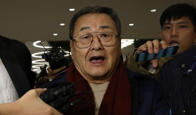 김준기 전 DB그룹(옛 동부그룹) 회장이 23일 새벽 인천국제공항을 통해 귀국한 뒤 체포돼 경찰서로 이송되는 중에 기자들의 질문을 받고 있다.ⓒ연합뉴스