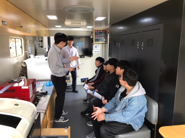 한국석유관리원 직원들이 이동시험실차량 내에서 학생들에게 운영 방법을 설명하고 있다.ⓒ한국석유관리원