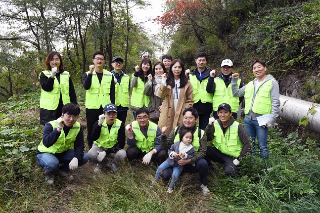 유진투자증권 임직원들이 지난달 26일 서울 상암동 노을공원에서 식목 활동 전 기념촬영을 하고 있다.ⓒ유진투자증권