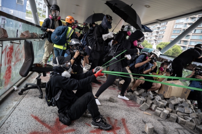 홍콩 시위대 중 한 명이 간이 투석기를 제작해 경찰들을 향해 돌을 날리고 있다. ⓒ사진=AFP