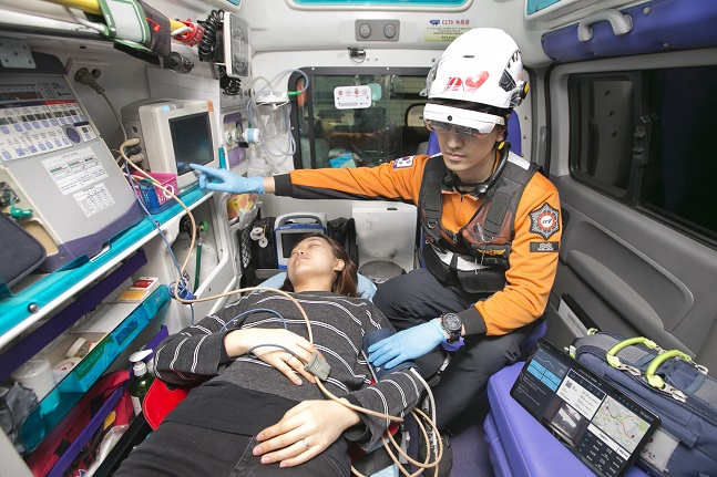 119 구급차 안에서 구급대원이 KT 5G AR 글래스와 360도 카메라로 세브란스 병원 의료진과 대화하며 환자를 돌보고 있다.ⓒKT