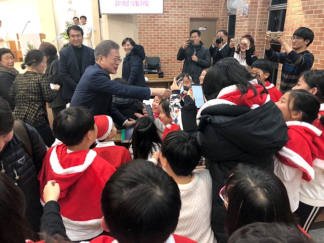 문재인 대통령이 2018년 12월 24일 오후 경남 양산시 덕계성당에서 열린 성탄 전야 미사에 참석해 어린이들과 반갑게 인사하고 있다.ⓒ청와대