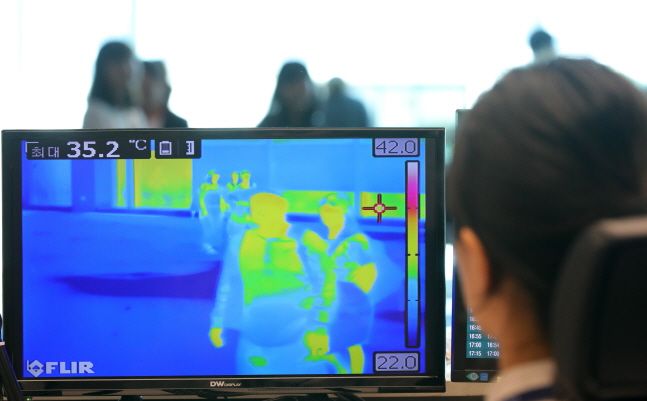 인천국제공항 제2터미널 입국 게이트에서 질병관리본부 국립검역소 직원이 열화상 카메라로 승객들의 체온을 재고 있다.