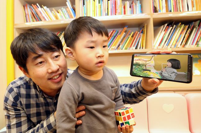 LG유플러스 고객과 자녀가 AR 교육 앱 ‘U+아이들생생도서관’을 이용하고 있다.ⓒLG유플러스