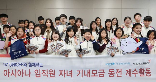 아시아나항공 임직원 자녀들이 지난 17일 서울 강서구 아시아나항공 교육훈련동에서 '사랑의 기내 동전 모으기 캠페인'으로 모인 동전의 계수 봉사활동에 참여해 기념사진을 찍고 있다.ⓒ아시아나항공