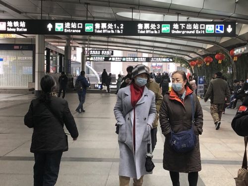 21일 중국 후베이성 우한시 한커우 역 앞 거리에서 마스크를 쓴 시민들이 걷고 있다. '우한 폐렴'의 진원지인 우한에서는 내달 3일부터 도쿄올림픽 복싱 예선전이 열린다. ⓒ 연합뉴스