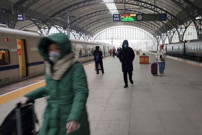 폐렴이 강타한 중국 우한에서 지난 23일 봉쇄령이 내려지기 직전 몇몇 사람들이 기차역 플랫폼에서 마스크를 쓴 채 걸어가고 있다.ⓒAP/뉴시스
