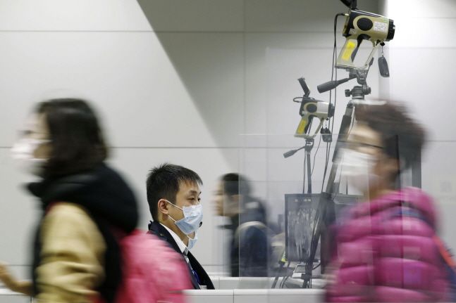 일본 오사카에 위치한 간사이 공항에서 마스크를 쓴 사람들이 체온측정 카메라 앞을 지나치고 있다.ⓒ뉴시스