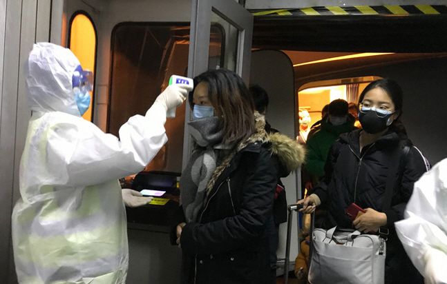 정부가 우한폐렴(신종 코로나바이러스 감염증)의 발원지인 중국 우한에 체류 중인 교민과 유학생을 철수시키기 위해 전세기 투입을 고려 중인 가운데 탑승 신청자가 700명에 육박한 것으로 나타났다. 사진은 지난 22일 중국 베이징 공항에서 보호복을 입은 보건 관계자들이 우한시에서 도착한 승객들의 체온을 체크하고 있는 모습.ⓒ뉴시스