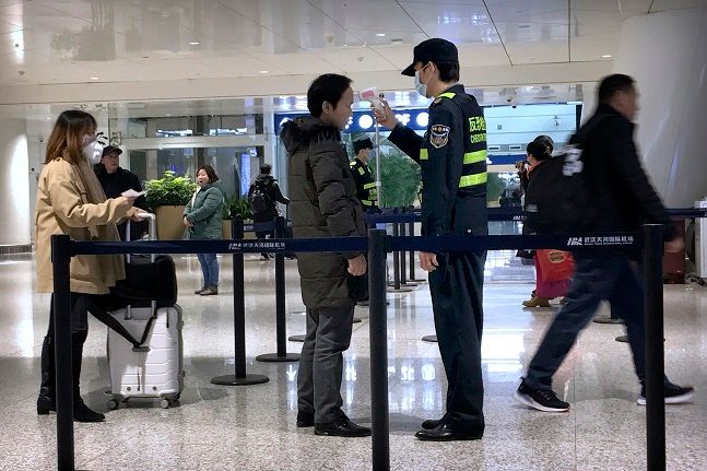 21일(현지시간) 중국 후베이성 우한시 국제공항에서 한 검역요원이 승객의 체온을 체크하고 있다.ⓒ뉴시스