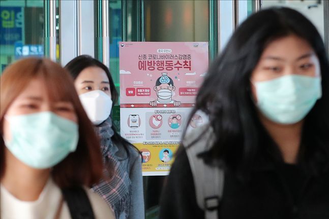 지난 28일 오전 서울 용산구 서울역에 부착된 신종 코로나 바이러스 감염증 관련 포스터 옆으로 마스크를 착용한 시민들이 길을 지나고 있다.ⓒ데일리안 홍금표 기자