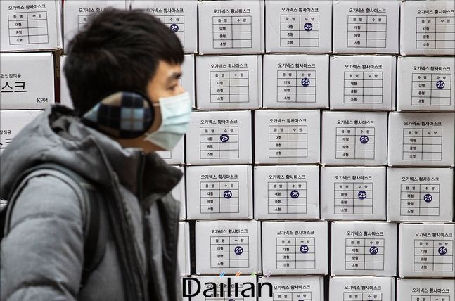 서울 명동의 한 약국 앞에서 마스크를 착용한 관광객의 너머로 마스크 제품 박스가 쌓여 있다(자료사진). ⓒ데일리안 홍금표 기자