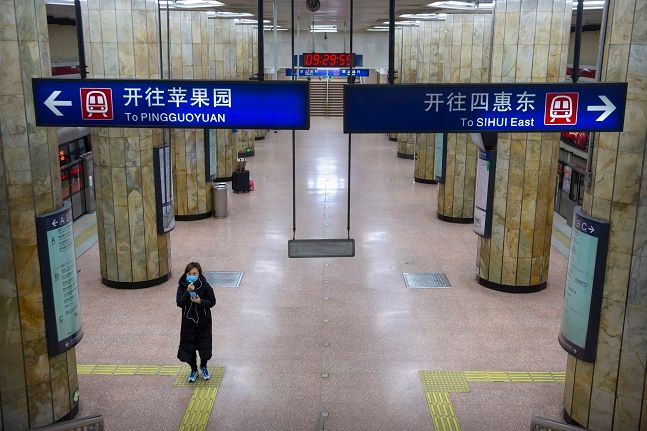 3일(현지시간) 중국 베이징에서 마스크를 쓴 한 여성이 출근 시간대 한산한 지하철역을 걸어 나오고 있다. 신종 코로나바이러스 감염증(우한 폐렴) 발발로 연장됐던 춘제 연휴가 끝나면서 대부분 공식 업무에 복귀했으나 지역의 비필수 업무에 관해서는 휴업이나 재택근무가 권유되면서 베이징 거리가 대체로 비어있는 것으로 나타났다.ⓒ뉴시스