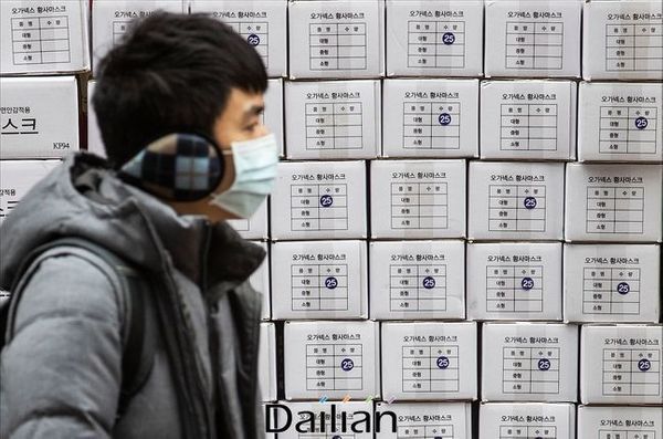 서울 명동의 한 약국 앞에서 마스크를 착용한 관광객의 너머로 마스크 제품 박스가 쌓여 있다(자료사진). ⓒ데일리안