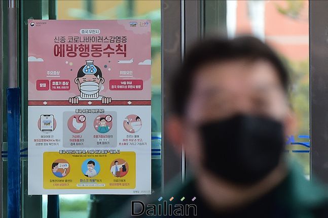 신종 코로나바이러스 감염증(코로나19) 관련 포스터 옆으로 마스크를 착용한 시민이 길을 지나고 있다.(자료사진) ⓒ데일리안 홍금표 기자