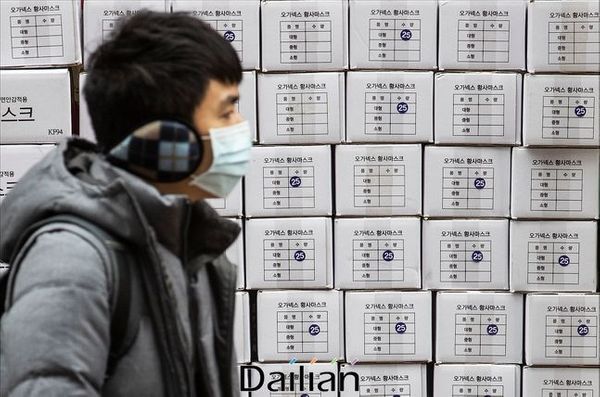 서울 명동의 한 약국 앞에서 마스크를 착용한 관광객의 너머로 마스크 제품 박스가 쌓여 있다.ⓒ데일리안 홍금표 기자