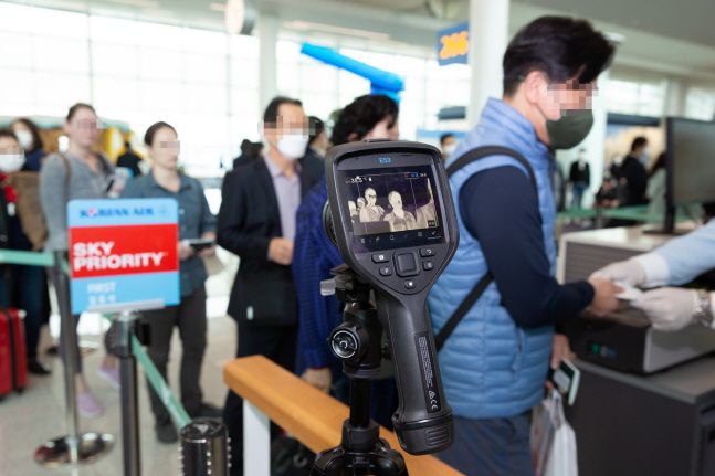 대한항공 직원들이 28일 인천국제공항에서 인천발 미국 로스앤젤레스(LA)행 KE017편에 탑승하는 승객들을 대상으로 열화상카메라를 통해 발열체크를 하고 있다.ⓒ대한항공