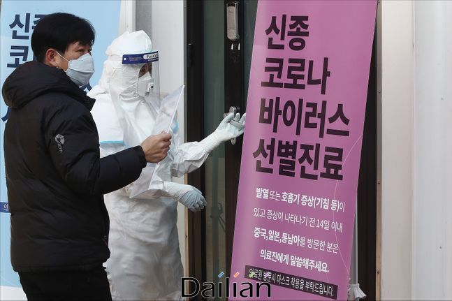 방역복을 입은 의료진과 마스크를 착용한 남성이 선별진료소로 함께 들어가고 있다(자료사진). ⓒ데일리안 홍금표 기자