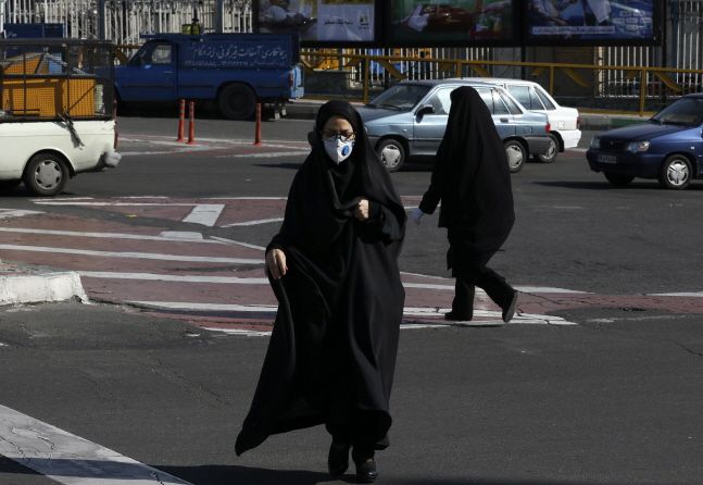 이란 테헤란 북부의 한 교차로에서 마스크를 쓴 여성이 길을 건너고 있다.ⓒ뉴시스