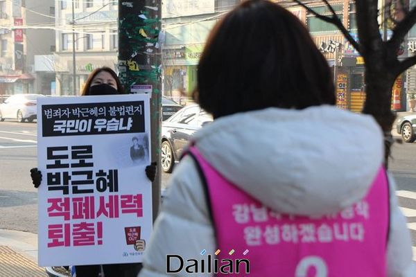나경원 통합당 의원의 선거운동 현장에서 친여 성향 지지자로 보이는 한 여성이 피켓을 들고 시위를 벌이고 있다. ⓒ나경원 의원 페이스북
