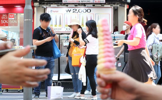 지난해 여름 서울 중구 명동거리를 찾은 관광객들이 아이스크림을 먹으며 더위를 식히고 있다. ⓒ뉴시스