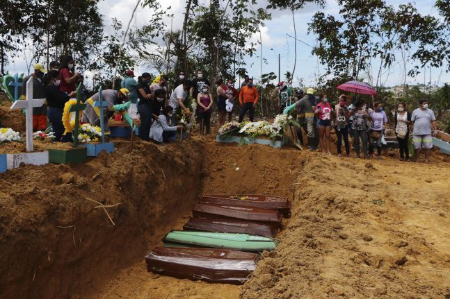 21일(현지시간) 브라질 아마조나스주 마나우스의 한 공동묘지에서 신종 코로나바이러스로 숨진 사망자 시신을 집단매장하고 있다.ⓒ뉴시스