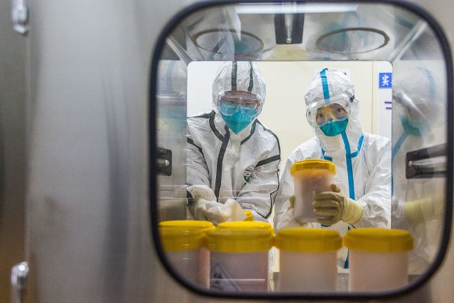 2월 25일 중국 베이징의 중국질병통제예방센터 연구실에서 직원들이 저장성 질병통제예방센터에서 보내온 신종 코로나바이러스 변종을 검사하고 있다.ⓒ뉴시스/신화