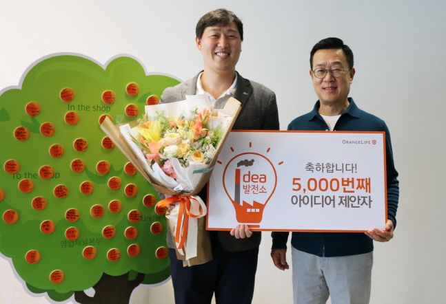 정문국 오렌지라이프 사장이 서울 순화동 오렌지센터에서 사내 혁신을 위한 '아이디어발전소'에 5000번째 아이디어를 제안한 이상학 고객전략챕터 과장과 기념촬영을 하고 있다.ⓒ오렌지라이프