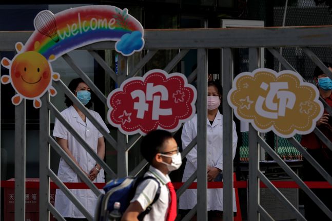 중국 베이징의 한 초등학교에서 마스크를 착용한 보건 교사들이 등교하는 학생들을 기다리고 있다.ⓒAP/뉴시스