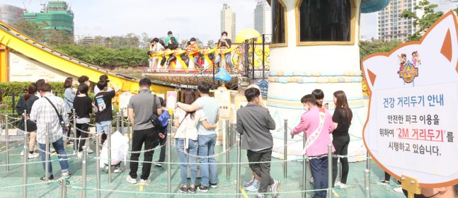 서울 송파구 롯데월드를 찾은 시민들이 놀이기구를 타기 위해 사회적 거리두기로 줄을 서고 있다.ⓒ뉴시스