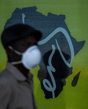 남아프리카공화국 요하네스버그의 인구 밀집 지역인 알렉산드라 마을 거리에서 신종 코로나바이러스 감염증(코로나19) 확산을 막기 위해 마스크를 쓴 한 남성이 아프리카 지도 그림 앞을 지나고 있다.ⓒ뉴시스