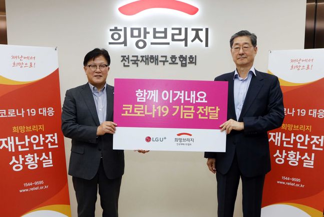 박형일 LG유플러스 CRO 전무(왼쪽)가 서울 마포구 희망브리지 전국재해구호협회에서 송필호 회장에게 ‘U+로드 온라인장터’ 모금액을 전달한 뒤 기념촬영을 하고 있다.ⓒLG유플러스