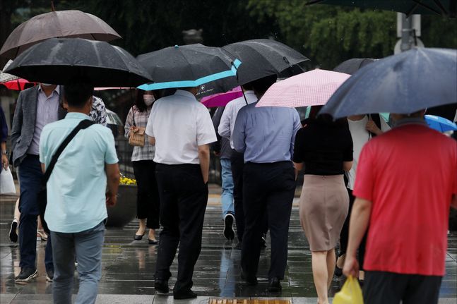 지난 24일 오후 서울 종로구 광화문 거리에서 우산을 쓴 시민들이 내리는 장맛비 속에서 발걸음을 옮기고 있다.ⓒ데일리안 홍금표 기자