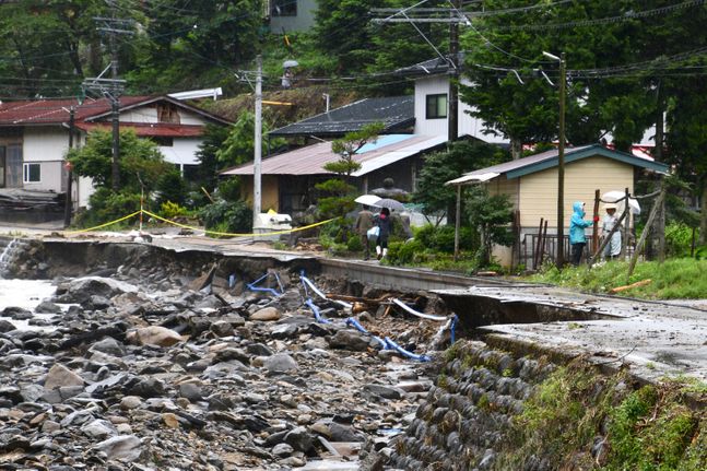 일본의 기록적 폭우로 인한 인명 피해가 계속 늘고 있는 것으로 나타났다. 사진은 지난 10일 일본 기후현 다카야마에서 주민들이 호우로 유실된 도로를 걷고 있는 모습.ⓒ뉴시스