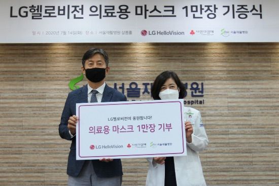 윤용 LG헬로비전 전무(왼쪽)가 지난 14일 서울시 은평구 서울재활병원에서 이지선 병원장에게 마스크 1만장을 전달한 뒤 기념촬영을 하고 있다.ⓒLG헬로비전