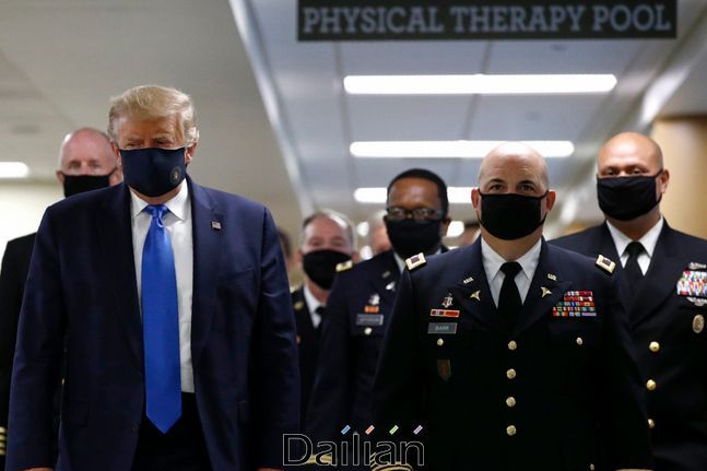 도널드 트럼프(왼쪽) 미국 대통령이 지난 11일(현지시각) 미 메릴랜드주 베데스다의 월터 리드 국립 군 의료원을 방문, 마스크를 쓰고 군 관계자들과 복도를 걷고 있다(자료사진).ⓒAP/뉴시스