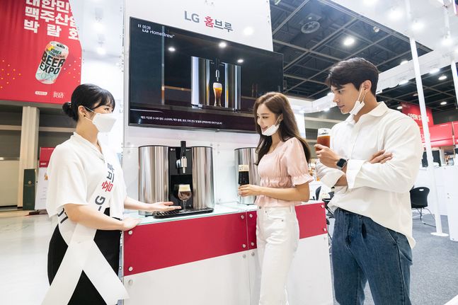 LG전자 직원들이 30일 서울 양재동 aT센터에서 열린 맥주박람회 ‘KIBEX 2020’에 참가해 캡슐형 맥주제조기 ‘LG 홈브루’에서 갓 뽑아낸 프리미엄 수제맥주를 선보이고 있다.ⓒLG전자