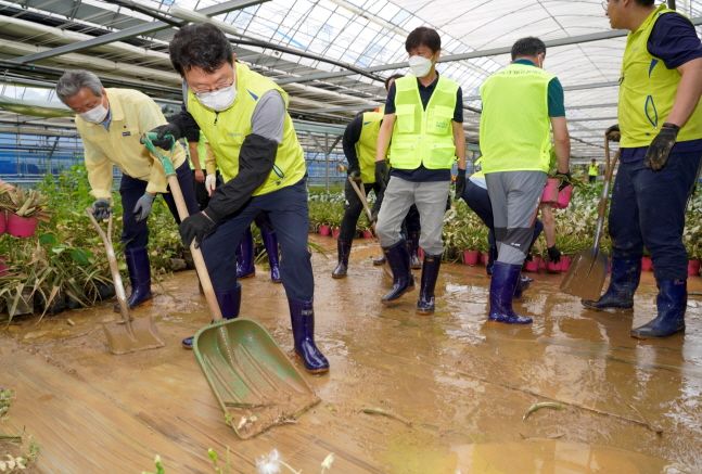 김광수(왼쪽에서 두 번째) 회장과 정재영(맨 왼쪽) 이사 등 NH농협금융지주 임직원 봉사단들이 7일 수해로 어려움을 겪고 있는 경기 용인시 소재 화훼 농가를 방문해 토사 정리 작업을 하고 있다.ⓒNH농협금융지주