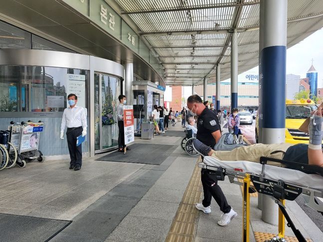 27일 서울 종로구 서울대병원 본관에서 파업 피켓을 든 의사 앞으로 응급환자가 지나고 있다. ⓒ데일리안