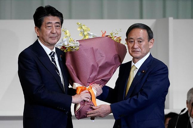 스가 신임 총재에 꽃다발 전하는 아베 총리 ⓒAP/뉴시스