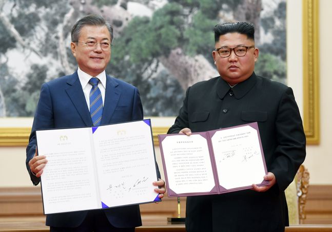 문재인 대통령과 김정은 북한 국무위원장이 2018년 9월 19일 오전 평양 백화원 영빈관에서 평양공동선언문에 서명한 후 합의서를 들어보이고 있다. ⓒ