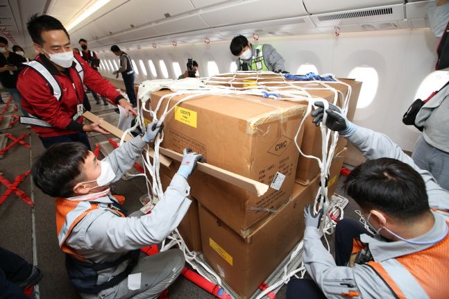아시아나항공 및 조업사 직원들이 24일 인천국제공항 제 1여객터미널에서 화물기로 개조한 A350 항공기 기내에 수출화물을 탑재하고 있다.ⓒ아시아나항공