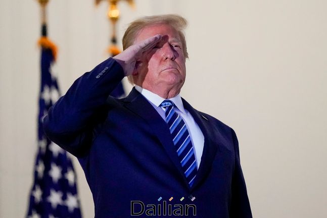 도널드 트럼프 미국 대통령이 5일(현지시각) 월터 리드 군 병원에서 퇴원한 뒤 백악관 발코니에 서서 전용 헬기 '마린 원'을 향해 경례를 하고 있다.ⓒAP/뉴시스