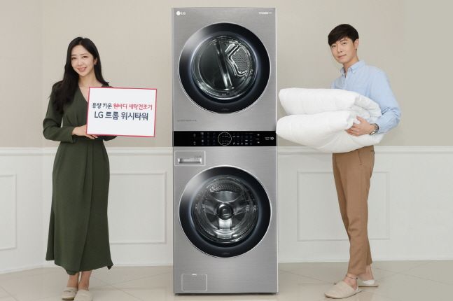 LG전자 모델들이 세탁기와 건조기의 용량을 모두 키운 원바디 세탁건조기 ‘트롬 워시타워’ 신제품을 소개하고 있다.ⓒLG전자