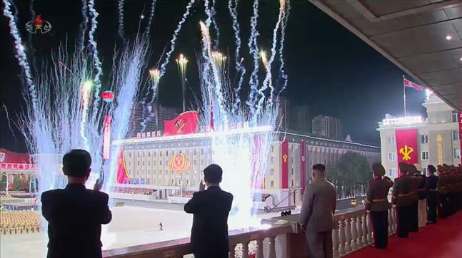 북한 노동당 창건 75주년 기념 열병식에서 김정은 국무위원장(가운데)이 불꽃을 바라보고 있다. ⓒ조선중앙TV 갈무리