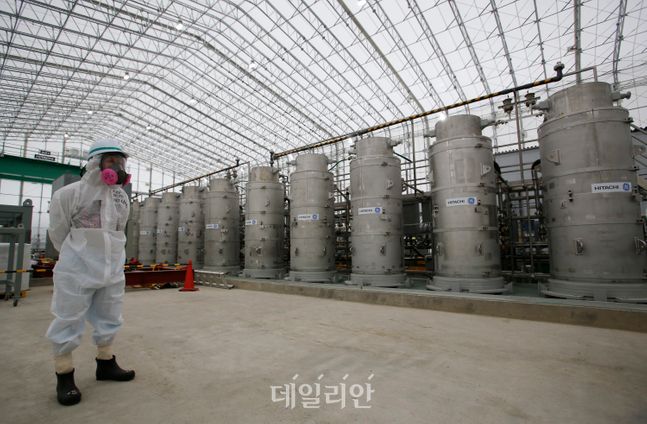 일본 후쿠시마현 오쿠마에 있는 원전 오염수 처리시설에서 한 직원이 방사성 물질 보호복을 입고 서있다(자료사진). ⓒAP/뉴시스
