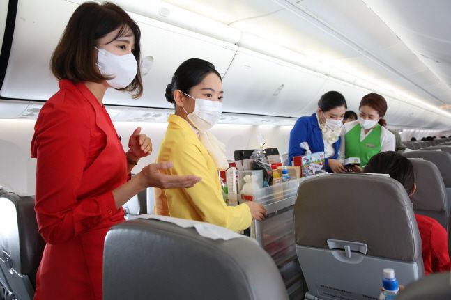 티웨이항공이 21일 마련한 '승무원 체험 비행' 프로그램에 참여한 배재대학교 항공운항과 학생들이 기내에서 승객들에게 음료 서비스를 하는 체험을 하고 있다.ⓒ티웨이항공
